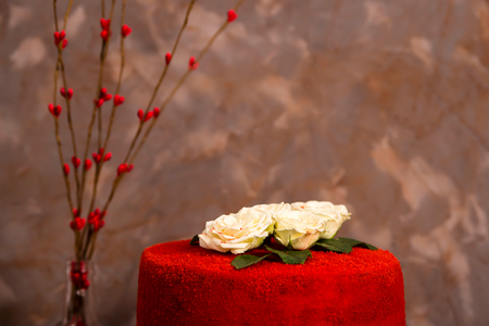 Beautiful red velvet birthday cake decorated with white roses on a glass stand against a gray dark background. Luxury pastry cakesの写真素材