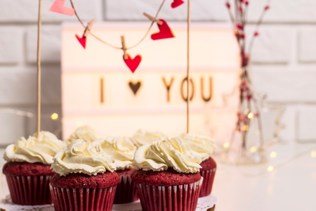I love you written on a decorative lamp next to red cupcakes, red velvet with mascarpone cream. Valentine's day conceptの写真素材