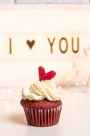 I love you written on a decorative lamp next to red cupcakes, red velvet with mascarpone cream. Valentine's day conceptの写真素材