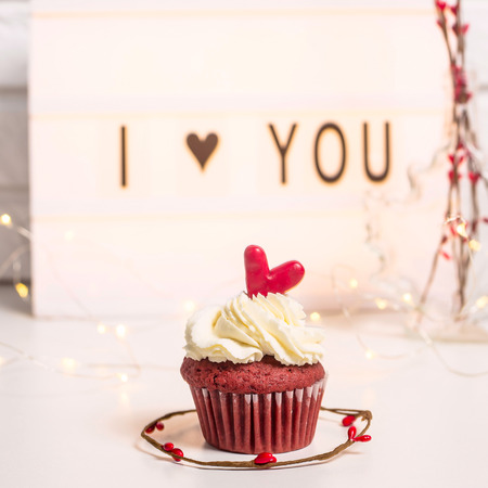I love you written on a decorative lamp next to red cupcakes, red velvet with mascarpone cream. Valentine's day conceptの写真素材