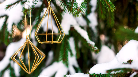 The branches of the Christmas tree covered with snow outdoor decorated with gold metal minimalist figures. Winter background conceptの写真素材