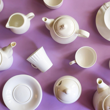 White stylish minimalist dishes for coffee and tea on a purple bright background. Tableware Concept. Top viewの写真素材
