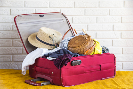 Suitcase full of womens clothing for summer holidaysの写真素材