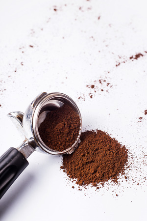 Metal holder from the coffee machine with ground coffee inside on a gray minimalistic backgroundの写真素材