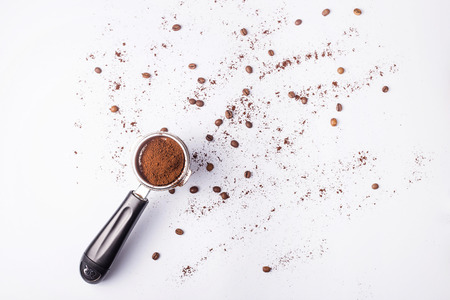 Metal holder from the coffee machine with ground coffee inside on a gray minimalist background. Top view, flat layの写真素材