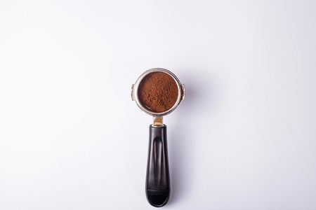 Metal holder from the coffee machine with ground coffee inside on a gray minimalistic background. Top view, flat layの写真素材