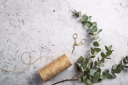 Eustoma flowers and eucalyptus on a gray textural table next to the florist's scissors ready to create a bouquet. Top view, flat layの写真素材