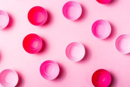 Small pink silicone molds for baking muffins or making sweets on a pink background. Confectioner's utensilsの写真素材