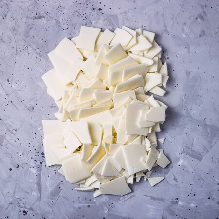 Broken white chocolate bars on a gray table - an ingredient for making dessertsの写真素材