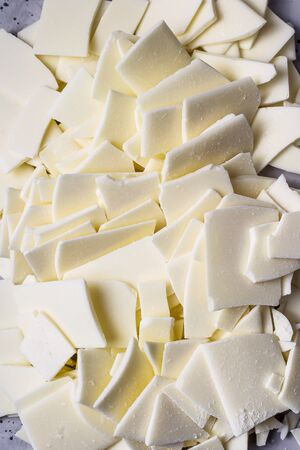 Broken white chocolate bars on a gray table - an ingredient for making dessertsの写真素材