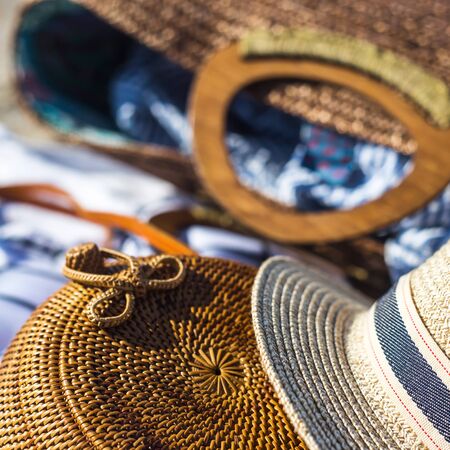 Straw hat and bag on a white bed which lies on the sand on the beachの写真素材