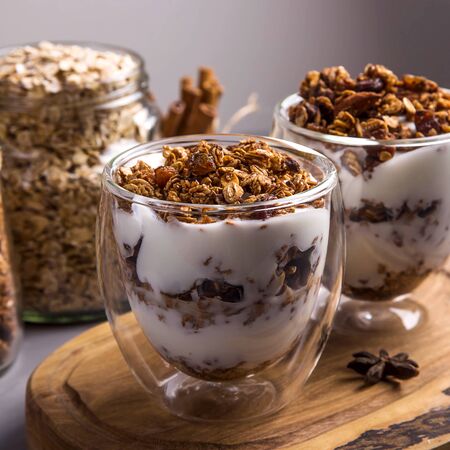 Dessert with granola and yogurt in glasses with double glass for breakfastの写真素材