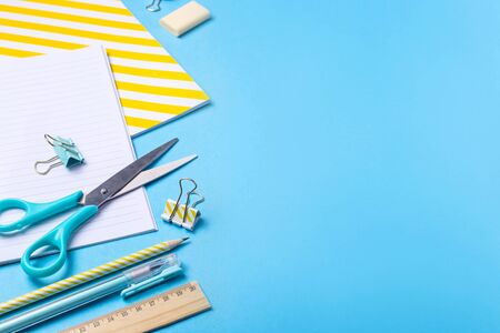 Bright modern minimalist stationery for school studies on a blue background. Back to school concept. Top view, flat layの写真素材
