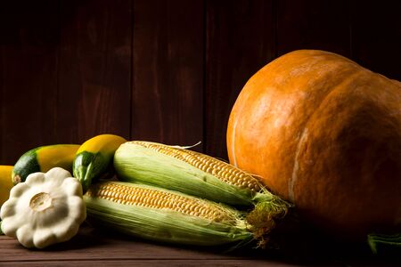 Autumn agricultural crop with pumpkin and other vegetables on a wooden tableの写真素材