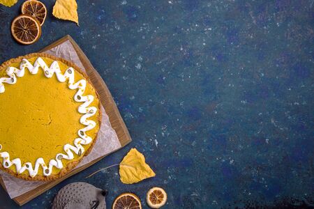 Traditional pumpkin pie with pumpkin twigs on a blue table for a family Thanksgiving party. Top view, flat lay, copy spaceの写真素材