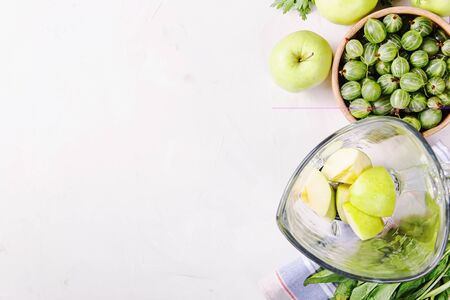 Ingredients for making healthy green smoothies made from apples, spinach, avocado and parsley around a blender glass bowl. Top view. flat lay, copy spaceの写真素材