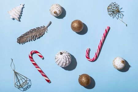 Christmas minimalist layout on a bright blue background with red-white candies and festive glittery decorationsT. op view, flat layの写真素材