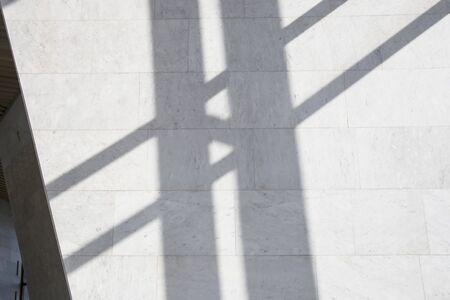 Shadows in a bright interior with marble walls on a bright sunny day. Background and trending shadow linesの写真素材