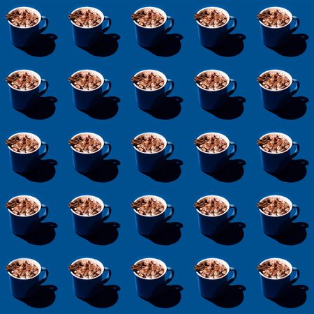 Hot chocolate with marshmallows and a stick of cinnamon on a classic blue background with hard light. Pattern in 2020 color of the year.の写真素材