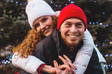 Loving boyfriend and girlfriend are hugging happily near a big city Christmas tree. Collage of two photos.の写真素材