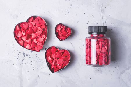 Valentines day concept. Confectionery powder in the form of red hearts on a gray concrete background.の写真素材