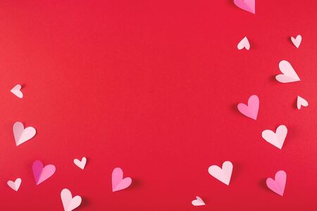 Red and pink hearts made of paper on a red background. Valentine's day and love concept. Copy space.の写真素材