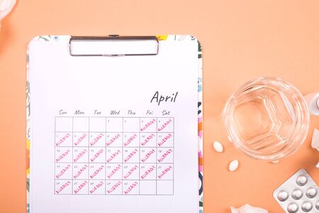 April calendar that says allergy. The concept of allergic tinitis and its treatment with pills. Top view, flat lay.の写真素材