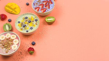 Beautiful multi-colored healthy smoothie bowls with berries and superfoods on a bright background. Summer food for detox concept. Background with copyspace.の写真素材