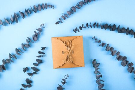 Mom love you written on a decorative panel next to a cup of coffee and eucalyptus on a blue background.の写真素材