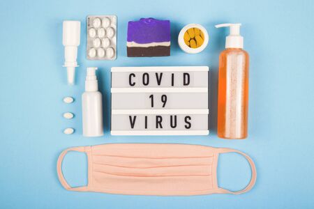 Medical mask on layout of the coronovirus. Covid 19 inscription. Top view. Quarantine concept.の写真素材