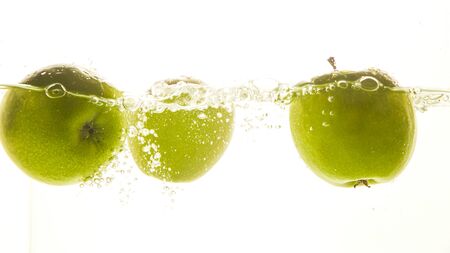 Green apples in the water with water splash on white background.の写真素材