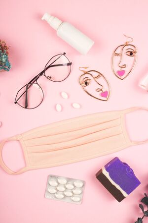 Pink medical mask for women to protect against the virus Kovid 19. The layout on a pink background. Spring 2020 style.の写真素材