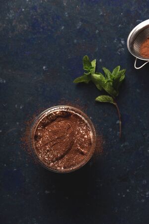 Serving of tiramisu garnished with cocoa and mintの写真素材
