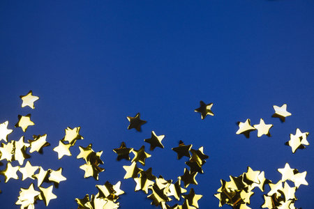 Gold candy made from stars on blue. Bright festive pattern