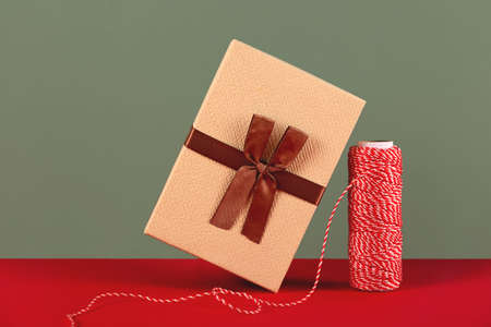 A balancing Christmas present next to a skein of red and white rope.の写真素材