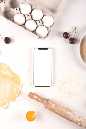 Cooking homemade mini cherry pie with isolated smartphone screen