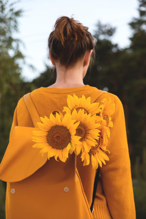 Girl with sunflowers in the autumn nature enjoys mindfulness