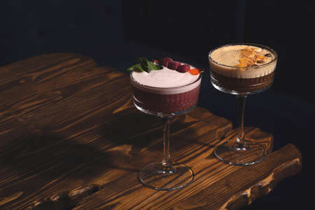 Raspberry and Coffee cocktails sour in a dark bar on a wooden tableの写真素材