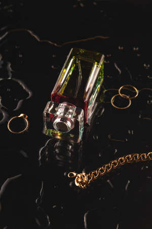 Beautiful accessories and womens perfume on a black background among the waterの写真素材