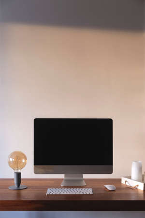Home workplace in an apartment against a light wall with shadowsの写真素材