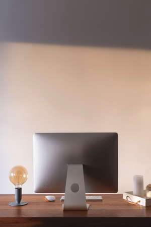 Home workplace in an apartment against a light wall with shadowsの写真素材