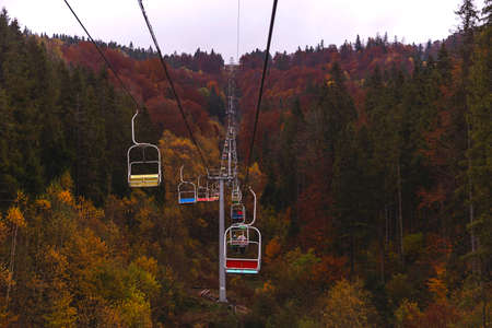 Open lift to the mountains among the autumn forestの写真素材