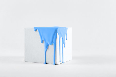 White cube with smudges of bright blue paintの写真素材