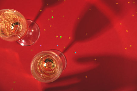 Stylish glasses of champagne on red background. Top viewの写真素材