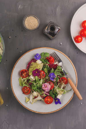 Beautiful healthy spring salad decorated with flowersの写真素材