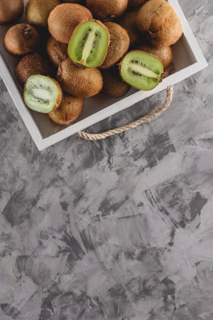 A tray with ripe whole and sliced kiwi on a gray background. Sleep product conceptの写真素材