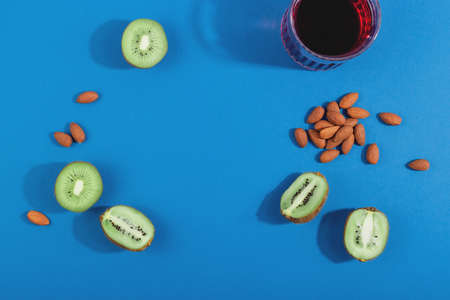 Treat insomnia with healthy sleep foods almonds, cherry juice and kiwi. Layout on blue backgroundの写真素材