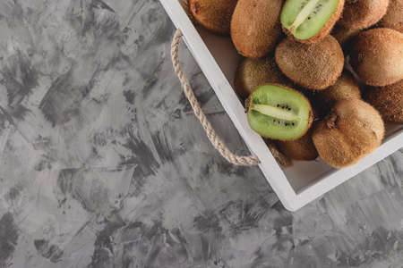 A tray with ripe whole and sliced kiwi on a gray background. Sleep product conceptの写真素材