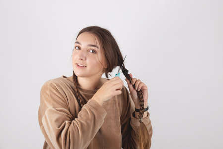 A woman cuts her long hair at home. Cardinal shocking image changeの写真素材
