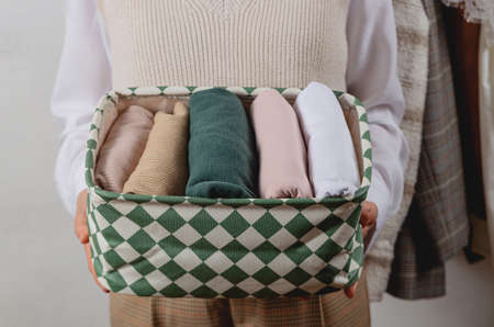 Vertical storage of clothes in a container. In the hands of a womanの写真素材